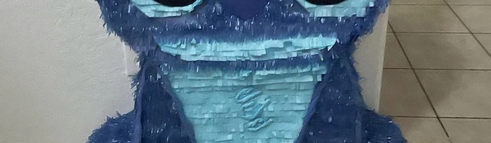 Close-up of rows of blue tissue-paper fringe across a pi&ntilde;ata's body