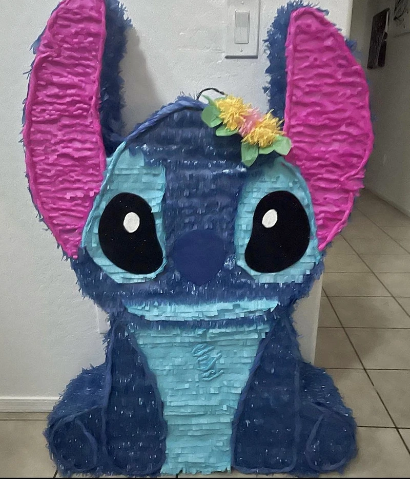 A large blue character pi&ntilde;ata with tall pink-lined ears and a flower behind one ear