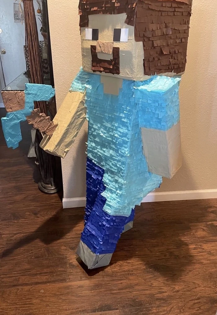 A life-size blocky video-game character pi&ntilde;ata standing in a doorway